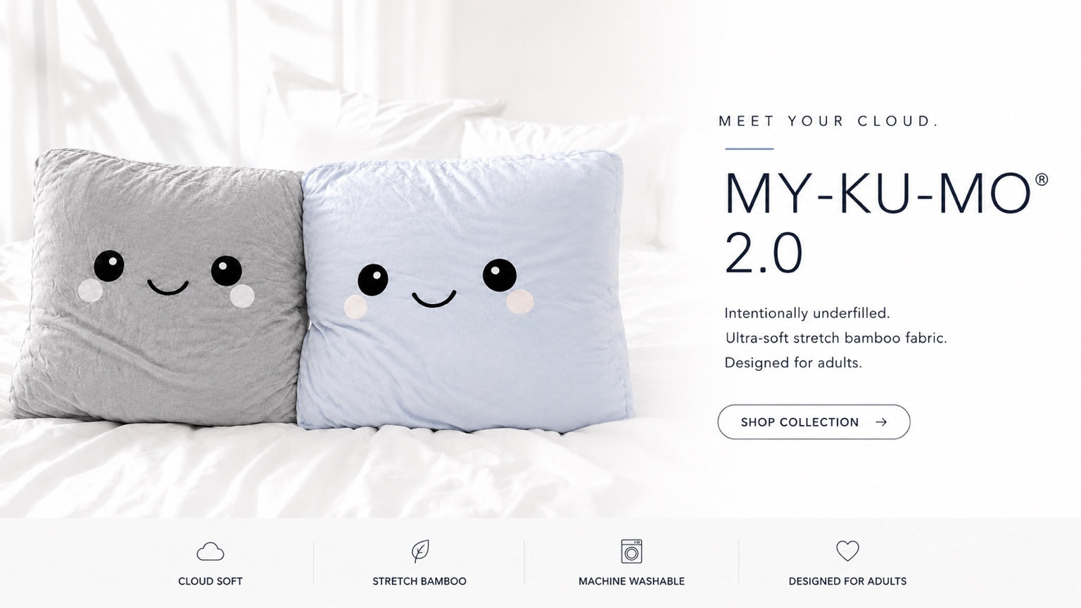 Two plush underfilled pillows with smiling cartoon faces, one light gray and one light blue, styled on a white bed. The image includes marketing text for 'MY-KU-MO 2.